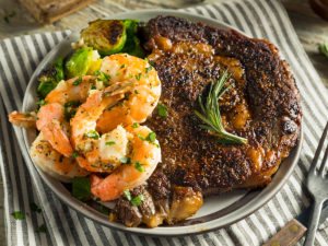 Surf and Turf Rump - steak topped with prawns and calamari in cream sauce with   grilled vegetables and mash potato